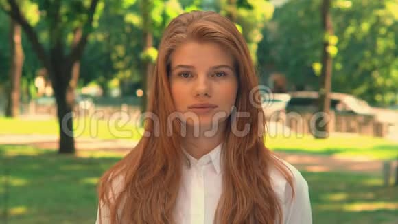 红头发的女人在城市公园摆姿势视频的预览图