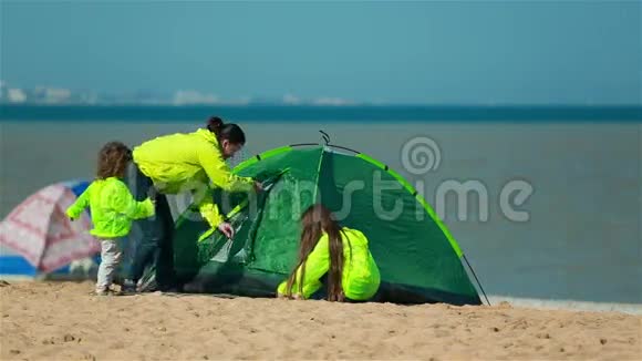 妈妈女儿和儿子去海滩上的绿色帐篷视频的预览图