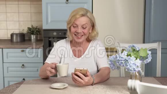 快乐的老妇人使用智能手机视频的预览图