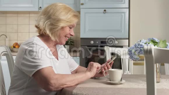 快乐的老妇人使用智能手机视频的预览图