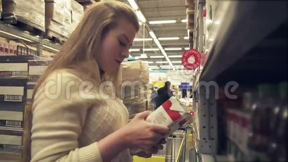 年轻女孩选择果汁超市股票视频视频的预览图