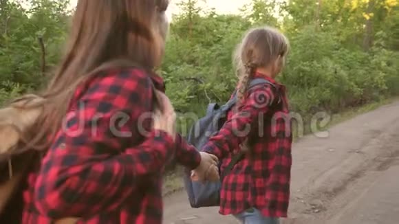 带着背包的女游客手牵着明亮的阳光沿着乡间小路奔跑徒步旅行者女孩儿童视频的预览图