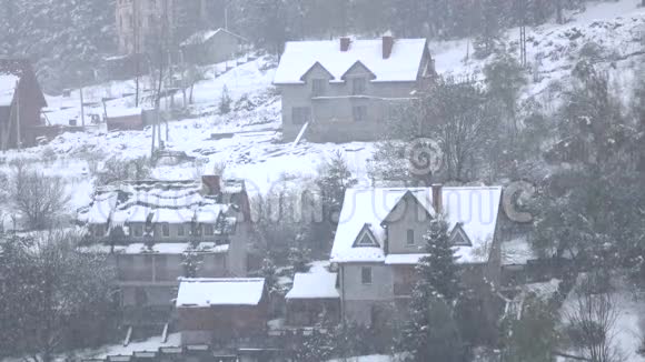 雪平静而平静地落在树林山的村庄视频的预览图