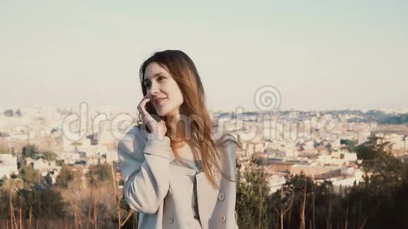 站在意大利罗马全景上的年轻美女肖像女人在智能手机上说话视频的预览图