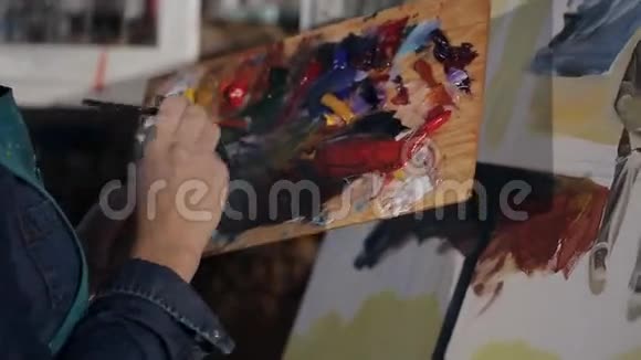 女孩艺术家用画笔在画布上作画艺术家手上的特写视频的预览图