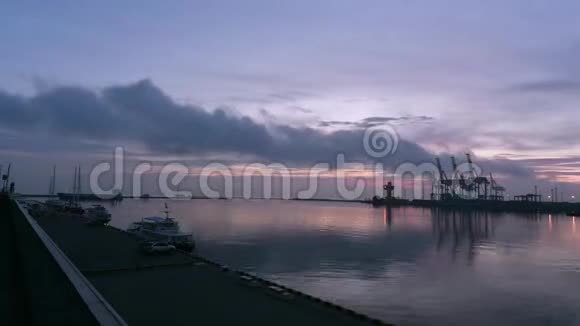 海港的黎明船和游艇在码头的波浪上摇摆一艘大型货船从港口游出视频的预览图