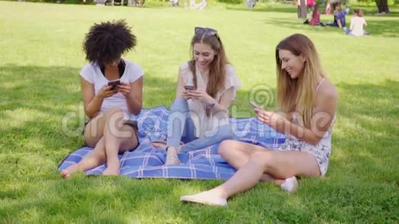 在草地上使用智能手机的女人视频的预览图