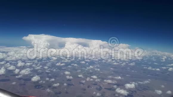 在阳光明媚的一天从飞机窗口看到蓝天和白云许多白云漂浮在上面视频的预览图