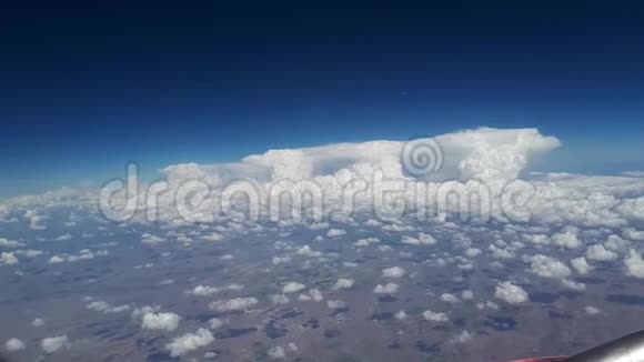 在阳光明媚的一天从飞机窗口看到蓝天和白云许多白云漂浮在上面视频的预览图