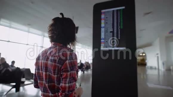 女孩站在机场并期待广告降落在飞机上布鲁内特考虑视频的预览图