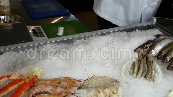 厨师的双手把新鲜的牡蛎放在一家海鲜餐馆的冰上视频的预览图