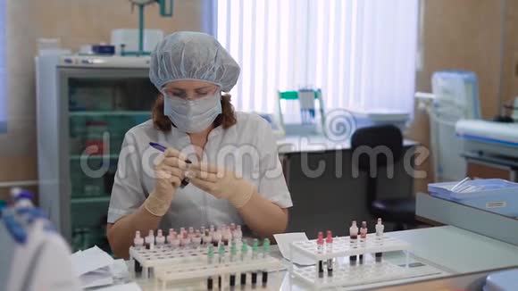 一位成年妇女在一家私人诊所的实验室工作一位戴着面罩的医生在脸上标记了视频的预览图
