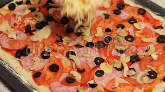 披萨基地比萨饼烹饪把奶酪放进披萨里把配料安排在披萨里洒上磨碎的视频的预览图