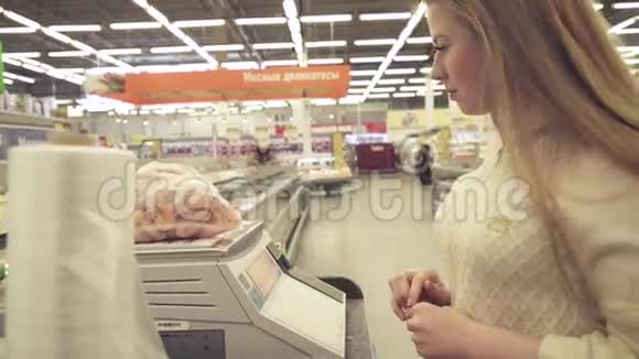 年轻女孩在超市的股票录像中体重秤上的冷冻虾视频的预览图