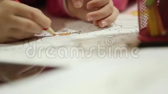 小孩子坐在桌上用铅笔画画视频的预览图