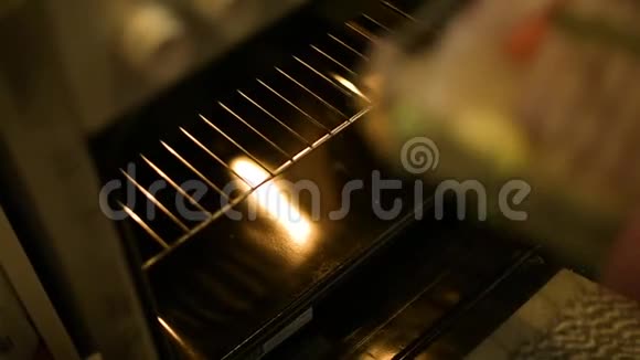 女人打开烤箱把肉放进去做饭视频的预览图