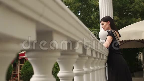 优雅的女孩倚在阳台的老栏杆上视频的预览图