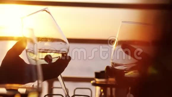 人们举着一杯白葡萄酒在夕阳下祝酒一起享受慢动作视频的预览图