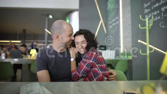 一对年轻快乐的夫妇在一家咖啡馆的桌子上他们期待着假期彼此交流视频的预览图