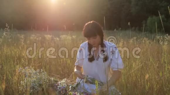 日落时分在草地上做花圈的女孩视频的预览图