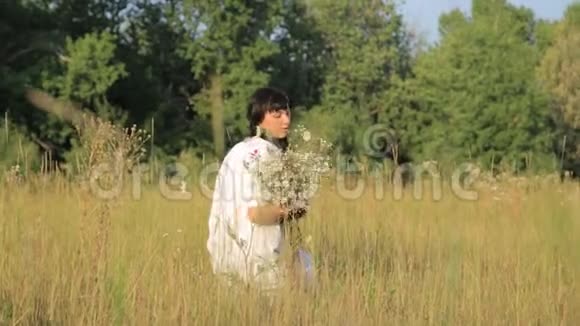 日落时分在草地上做花圈的女孩视频的预览图