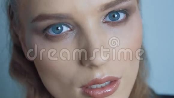 特写一幅蓝眼睛在白色背景上摆姿势的女人的肖像视频的预览图
