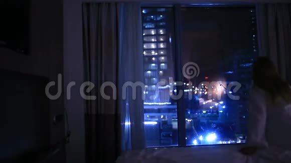 一个年轻的女人晚上关上窗帘上床睡觉视频的预览图