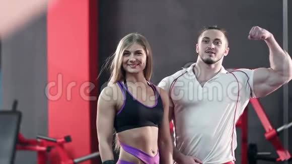 运动的年轻夫妇摆姿势炫耀他们的二头肌视频的预览图
