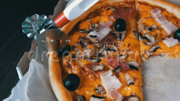 披萨刀将披萨切成圆形上面有橄榄培根意大利香肠和奶酪视频的预览图