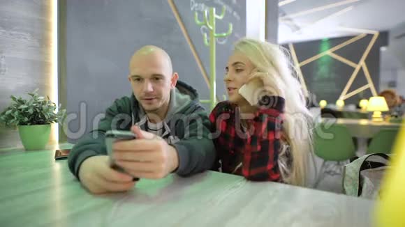 金发碧眼的金发女孩穿着一件格子红色衬衫厌倦了和朋友打电话坐在一个视频的预览图