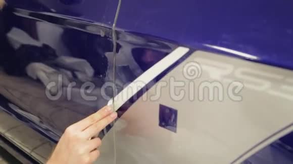一个人用一把锋利的刀把车门上的缝隙切开视频的预览图