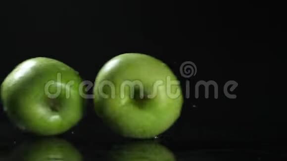 绿苹果落在黑色的背景上慢动作视频的预览图