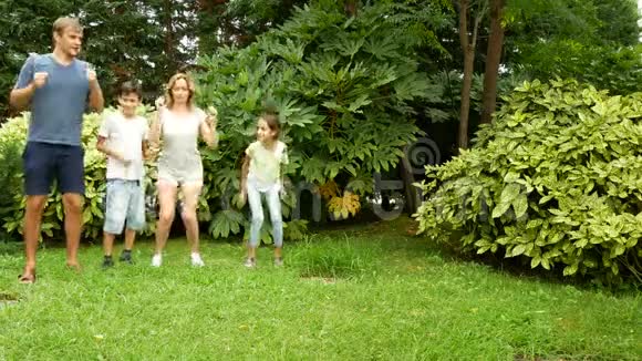 幸福的家庭在一个美丽的自然公园的草地上一起跳舞4k复制空间生活方式视频的预览图
