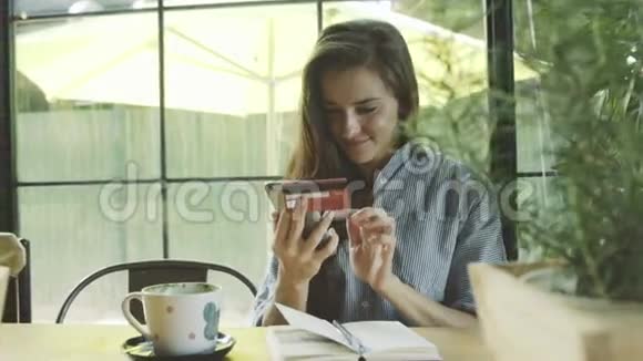 女人用手机信用卡成功购买视频的预览图