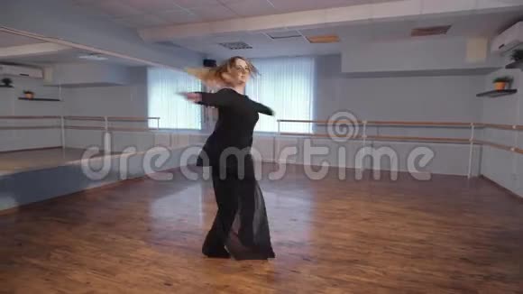一个女人在空荡荡的工作室里上舞蹈课这是她的爱好她排练时心情很好尝试做一个360视频的预览图