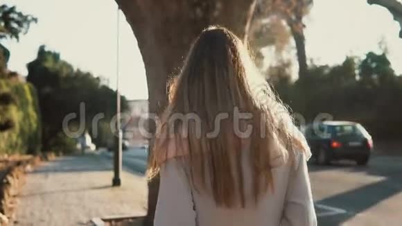 年轻女子独自在市中心散步的后景在阳光明媚的日子里一只健壮的雌性走近马路视频的预览图
