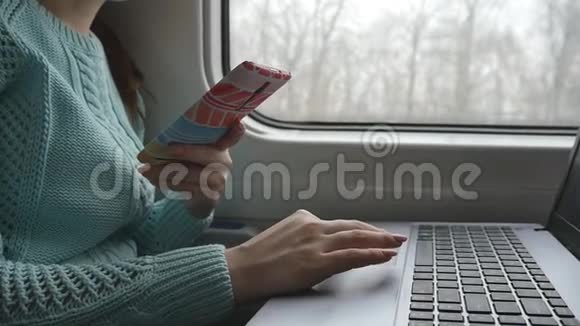 女性手在火车上使用笔记本电脑和智能手机的触摸板年轻女子触摸笔记本触摸屏的手臂视频的预览图
