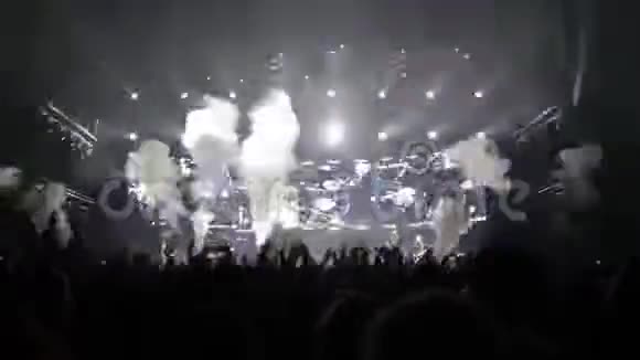 音乐会上的观众挥舞着手在舞台上表演灯光秀音乐会视频的预览图