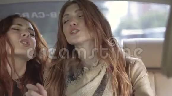 女孩们坐在车后座上疯狂跳舞女朋友一起玩得开心视频的预览图