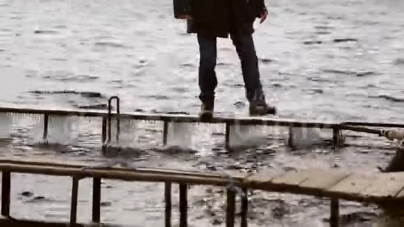 一个人在狭窄冰冷的码头上危险地行走视频的预览图