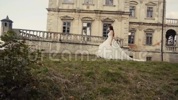 美丽的新娘在城堡前散步视频的预览图