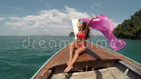 美丽的女人坐在泰国的船鼻动作镜头POV扬起粉红的帕雷奥女孩快乐的微笑视频的预览图