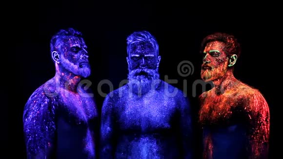 三个留胡子的男人在紫外线粉末中站立静止视频的预览图