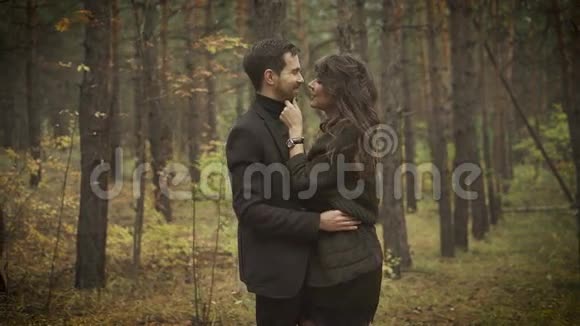 在森林里有个约会的快乐夫妻微笑的男人和女人站在树间互相拥抱视频的预览图