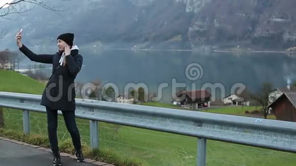 年轻漂亮的女孩在阿尔卑斯山的背景上自拍视频的预览图