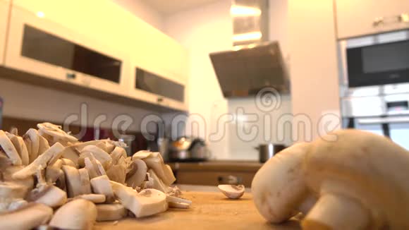男人在厨房里切田蘑菇业余烹饪在家4k特写视频视频的预览图