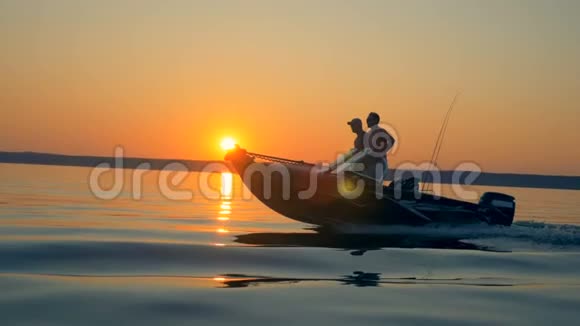 有两名渔民的摩托艇正在日出湖中漂浮视频的预览图