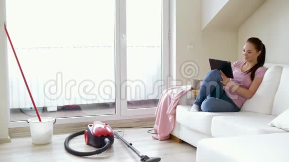 带平板电脑和茶的女人在家里打扫卫生视频的预览图