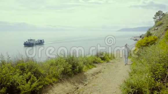 游客步行在贝加尔湖附近的乡村道路上在山上的小径视频的预览图