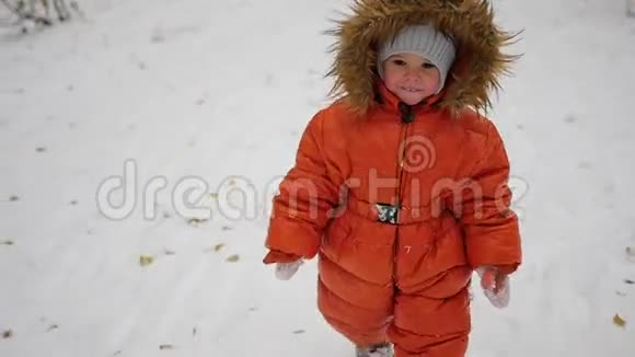 一个孩子走在冬天公园的雪道上视频的预览图